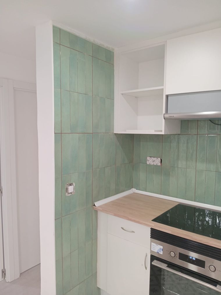 Cocina reformada con alicatado verde por Renacer Global en Madrid