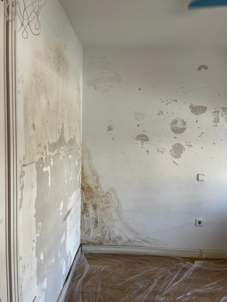 Pared con humedades antes de la reparación en un piso de Madrid