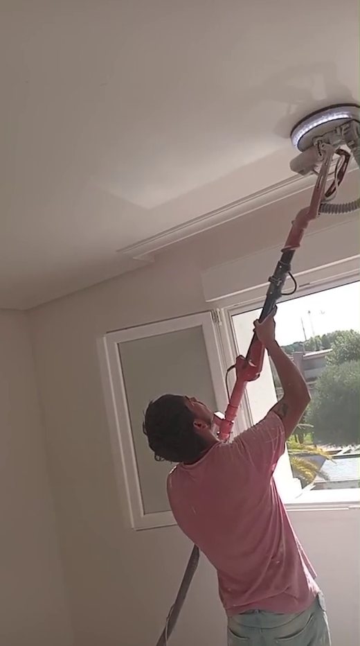 Pintor de Renacer Global lijando el techo con jirafa en un piso de Madrid